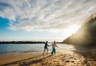 retired couple walking on a beach at sunset